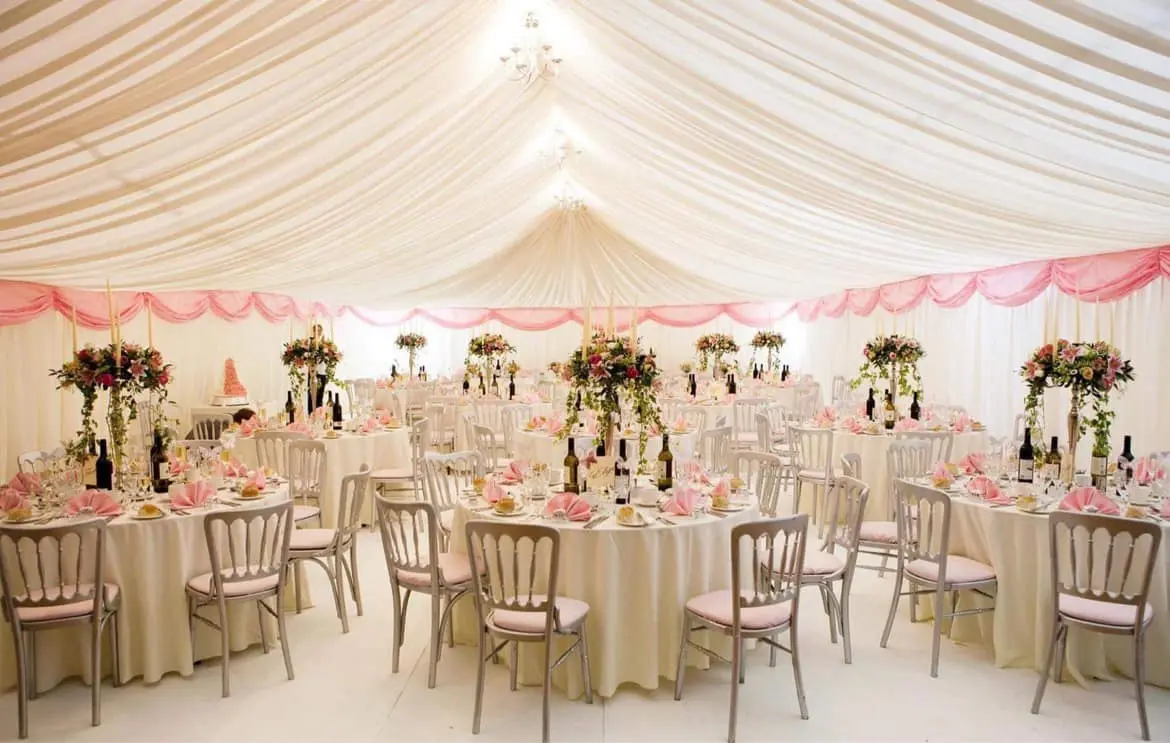The Main Hall elegantly transformed into a wedding reception venue with a white marquee-style ceiling lining and formal table settings.